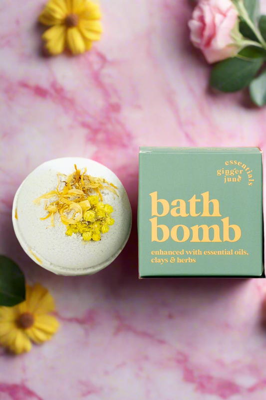 Bath bomb with yellow flowers and its packaging on a white background